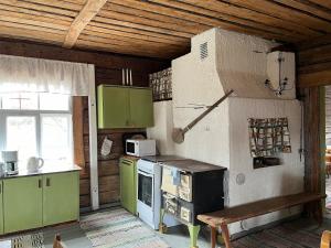 a kitchen with green cabinets and a stove at Vintage atmospheric log house in Kivijärvi