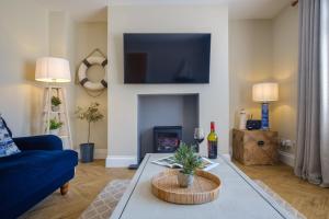 a living room with a blue couch and a fireplace at The Bolt Hole in Silverdale