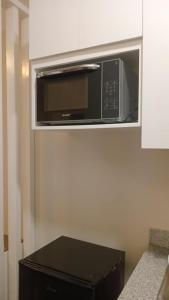 Un horno microondas encima de una caja negra en una cocina. en Studio Unit at Mesavirre, en Sampong