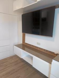 Un televisor colgado en la pared de una cocina. en Studio Unit at Mesavirre, en Sampong