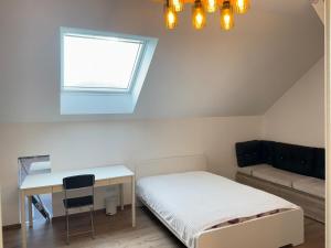 a bedroom with a bed and a desk and a window at New appartement in Turckheim