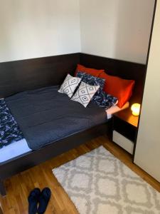 a bed with pillows on it in a room at Beli Apartman u Zlatiborskim konacima Bele vode bb in Zlatibor