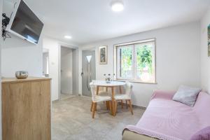 a bedroom with a table and a bed and a kitchen at Apartments and Rooms LEA in Bol
