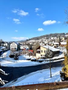 a snow covered city with houses and a road at Vlevo Dole 7 by Správa ubytka in Rokytnice nad Jizerou +1 photo
