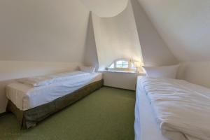 due letti in una piccola stanza con una finestra di Ferienwohnung in der Dorfstraße 47d a Ahrenshoop