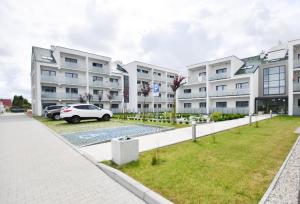 a building with a car parked in front of it at Apartament Black Sunset Resort SurfingBird Grzybowo in Grzybowo