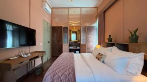a bedroom with a large white bed and a flat screen tv at Hotel Lost Ashrafieh in Beirut