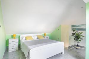 Un dormitorio con una cama blanca con almohadas amarillas. en Apartment Louis, en Supetar