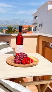 a bottle of wine sitting on a table with fruit at Mint Bellavista in Vir
