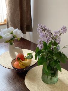 a table with a vase of flowers and a bowl of fruit at Beli Apartman u Zlatiborskim konacima Bele vode bb in Zlatibor