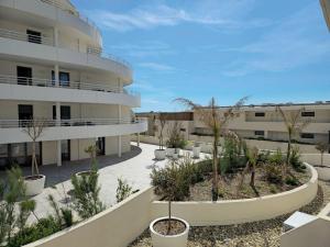 a building with a courtyard with trees and plants at Valras Panarea 4 people in Valras-Plage