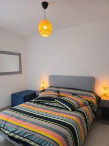 una camera da letto con un letto con una coperta colorata a righe di Valras Panarea 4 people a Valras-Plage
