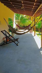 a hammock on the porch of a house at Pousada riacho santa cruz in Barreirinhas
