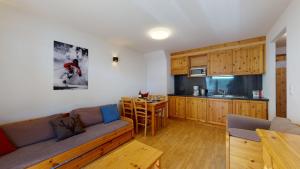 a living room with a couch and a kitchen at Pracondu 2 307 - OUTDOOR & FUN charming apartment in Nendaz