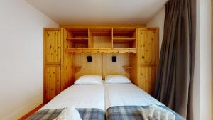 a bedroom with a bed with wooden walls and shelves at Pracondu 2 307 - OUTDOOR & FUN charming apartment in Nendaz