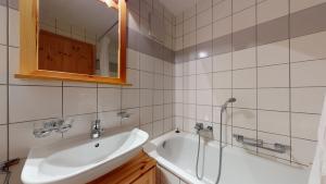 a bathroom with a sink and a tub and a mirror at Pracondu 2 307 - OUTDOOR & FUN charming apartment in Nendaz +3 photos