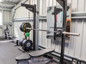 a gym with a barbell and a squat rack at Douglas Fir in Newtonmore