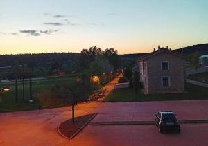 ein Auto, das auf einem Parkplatz neben einem Gebäude parkt in der Unterkunft Apartamento Rural Dehesa de Solanillos in Mazarete