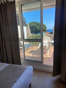 a bedroom with a view of a patio with an open window at Les Alcyons in Le Lavandou