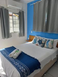 a bedroom with a large bed with blue walls and windows at Hospedaria da Praia Fortaleza in Fortaleza