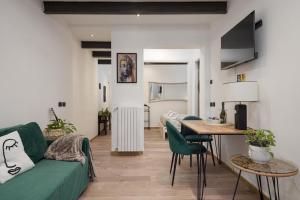 un soggiorno con un divano verde e un tavolo di Nadia's Lovely Home - WITH PRIVATE GARDEN AND JACUZZI a Firenze