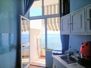 a kitchen with a view of the ocean from a balcony at Case Nereidi 3 in Porticello