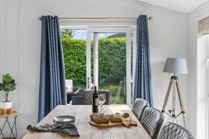 a dining room with a table and a window at Bluebell Lodge, 29 Roadford Lake Lodges in Lifton