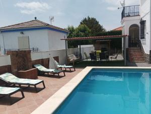 a swimming pool in front of a house at Casa las Mariposas, Tranquilidad junto a la piscina in Huétor Santillán