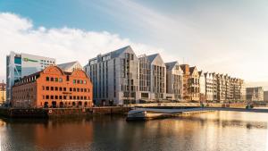 a city with tall buildings next to a river at Flatbook - City Center SPA Apartments Deo Plaza Studio in Gdańsk