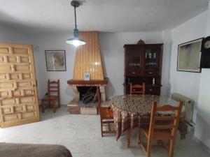 a living room with a table and a fireplace at Casa las Mariposas, Tranquilidad junto a la piscina in Huétor Santillán