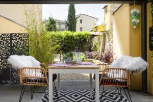 un patio con tavolo bianco e 2 sedie di Nadia's Lovely Home - WITH PRIVATE GARDEN AND JACUZZI a Firenze