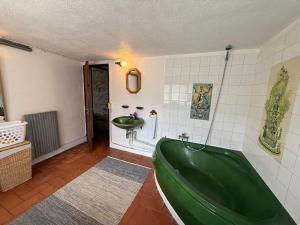 a bathroom with a green tub and a sink at Wood Lodge - Sleeps10 - Skiing - Thermal Baths in Los Masos +42 photos