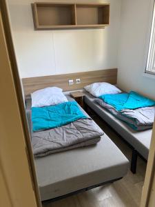 波讷地区圣朱利安mobilolo 1的小客房内的两张床,配有蓝色的床单