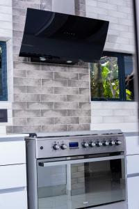 a stove top oven with a microwave above it at Zenz BnB in Empangeni