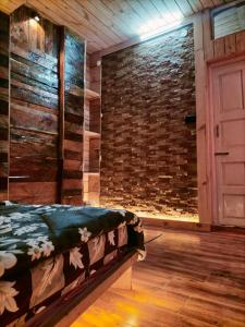 a room with a bed and a brick wall at RATAN HOMES Sunrise Valley in Jāmb