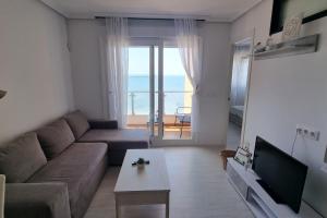 a living room with a couch and a tv and a table at Seaside Apartment Sleeps 6 with Balcony in Vilagarcia de Arousa