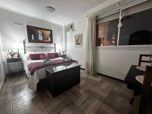 Un dormitorio con una cama y una mesa y una ventana. en En el Corazón de Salta, en Salta