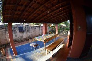 a patio with a table and benches on a patio at Casinha das bananeiras in Delfinópolis