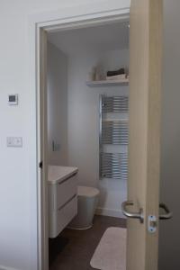 a white bathroom with a toilet and a sink at Cozy City Stay 2BR with Sofa Bed in Exmouth