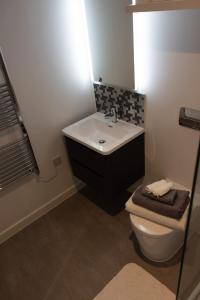 a bathroom with a white sink and a toilet at Cozy City Stay 2BR with Sofa Bed in Exmouth +15 photos
