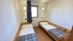 two beds in a room with a window at Pracondu 1 401 - OUTDOOR & FUN apartment 8 pers in Nendaz +5 photos