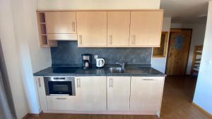 a kitchen with white cabinets and a sink at Pracondu 1 401 - OUTDOOR & FUN apartment 8 pers in Nendaz