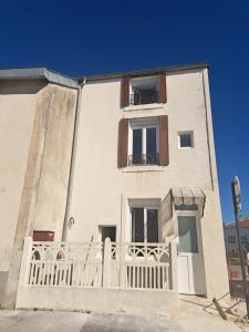 a building with a white fence in front of it at Chez Bigoude maison 4 voyageurs in Chaumont