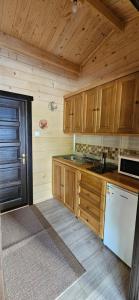 a kitchen with wooden cabinets and a white refrigerator at Forest Apartments in Sovata