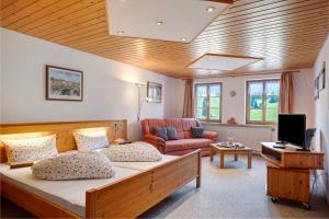 a room with a bed and a couch and a television at Ferienwohnung Otto Booz in Schluchsee