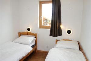 two beds in a room with a window at Pracondu 1 201 - OUTDOOR & FUN charming apartment in Nendaz +5 photos