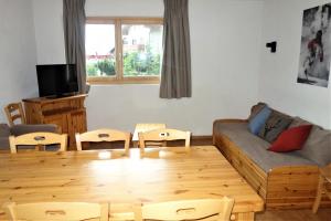 a living room with a couch and a table at Pracondu 1 201 - OUTDOOR & FUN charming apartment in Nendaz