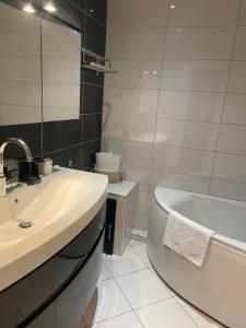 a white bathroom with a sink and a bath tub at Les Alcyons in Le Lavandou