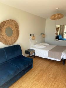 a bedroom with a bed and a couch and a mirror at Les Alcyons in Le Lavandou