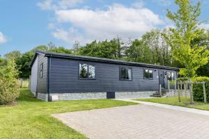 une maison modulaire noire avec une brique dans l'établissement Blossom Lodge, 1 Roadford Lake Lodges, à Lifton